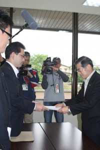 通知文書を受け取る菅野村長の画像