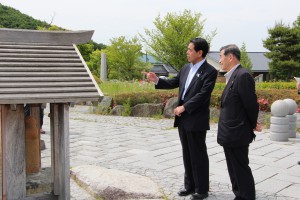 下村大臣と一緒に村民歌を聴く村長の画像